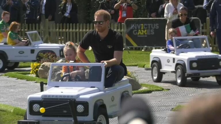 Harry and Megan ride a mini Land Rovers at the Invictus Games