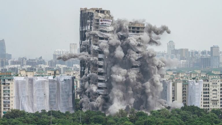 Explosives are detonated to bring down the high-rise twin towers in Noida, a suburb of New Delhi, India. Photo: AP